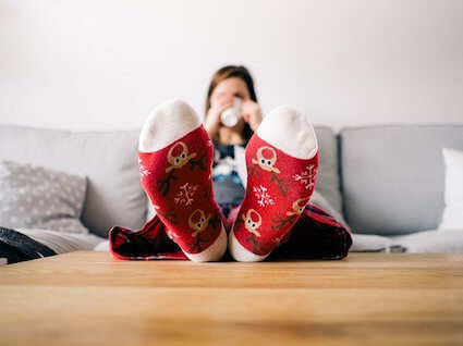 Woman-relaxing-on-a-couch-with-holiday-Christmas-socks